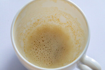 dirty white cup of coffee with milk. cup on white background after drinking coffee. cup with frothed milk
