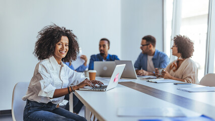 Smiling Woman at Team Meeting in a Modern Office Environment