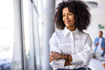 Confident Businesswoman Standing in Modern Office with Bright Natural Lighting