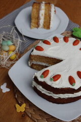 Sliced homemade carrot cake with mascarpone cream cheese icing and mini marzipan carrot decorations...