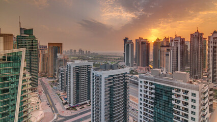 Obraz premium Sunrise view of various skyscrapers and towers in Dubai Marina from above aerial timelapse