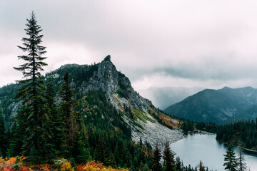Obraz premium Scenic View of Mt. McCausland and Alpine Lake in the Cascade Mountains – Dramatic Misty Landscape with Rugged Peaks, Lush Forests, and Remote Wilderness in the Pacific Northwest