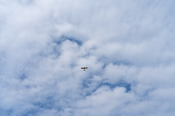 Vintage airplane gliding through overcast skies of La Roche-Guyon in a serene afternoon ambiance