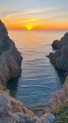 A tranquil sunset over a rocky coastline, reflecting warm hues on the calm sea.