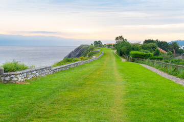 Paseo Mirador de San Pedro Llanes, Asturias, Spain with stone walls and sea views grassy garden area.
