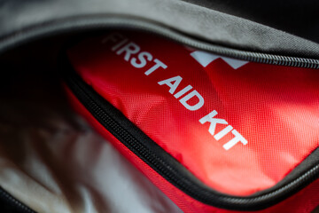 A bright red first aid kit is securely stored within a stylish black bag, ready for any emergency...