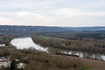 Exploring the picturesque view of La Roche-Guyon along the serene banks of the river in early winter