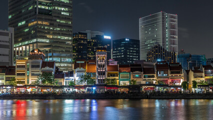 Obraz premium Singapore quay with tall skyscrapers in the central business district on Boat Quay night timelapse hyperlapse