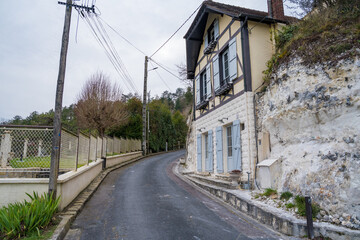 Explore the charming streets of La Roche-Guyon lined with historic houses and natural beauty on a tranquil day