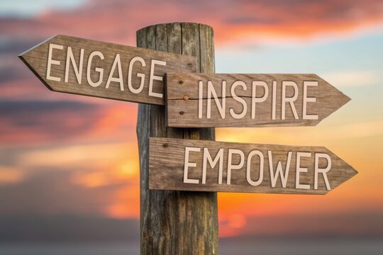 Employee engagement fosters loyalty and deeper workplace involvement concept. Wooden signpost with motivational words against a sunset background.