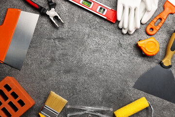 Frame made of different construction materials and tools on grey table, flat lay. Space for text