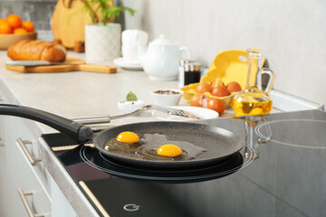 Cooking tasty eggs on frying pan in kitchen, closeup
