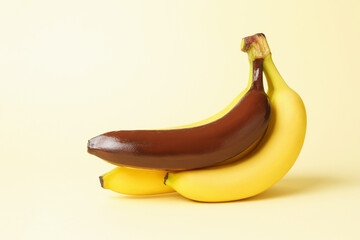 Stop racism. Bunch of yellow bananas with dark one on beige background
