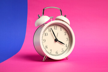 One white alarm clock on color background