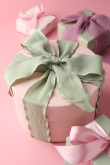 Different gift boxes with beautiful bows on pink background, closeup