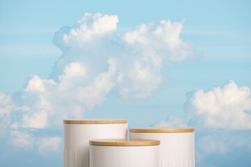 Minimal geometry cylinder podium stage with blue sky white fluffy clouds background.product placement pedestal modern stand display,surreal paradise dreamy concept.