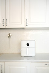 An elegant kitchen space featuring a stylish white air fryer, with clean lines and a beautifully minimalist decor.