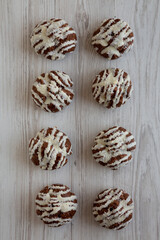 Homemade Profiteroles with Coconut Cream on a white wooden background, top view.
