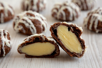 Homemade Profiteroles with Coconut Cream on a white wooden background, side view. Close-up.