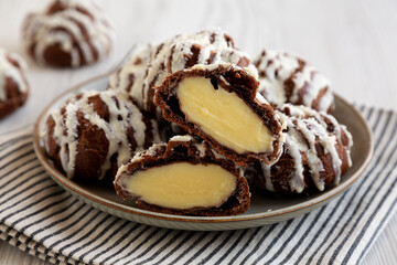 Homemade Profiteroles with Coconut Cream on a white wooden background, side view. Close-up.