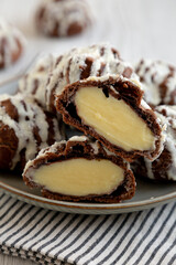Homemade Profiteroles with Coconut Cream on a white wooden background, side view. Close-up.