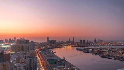 Fototapeta premium Cityscape of Ajman from rooftop day to night timelapse after sunset.