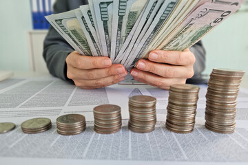 Counting cash and organizing coins on a table in an office setting during daylight hours concept