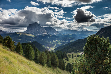 Naklejka premium Majestic views of Dolomites landscape near Seceda showcasing dramatic clouds and lush green valleys