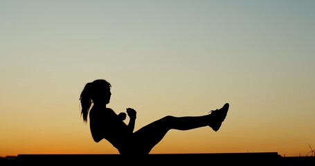 A passionate fitness enthusiast is engaged in exercise during a beautiful sunset hour