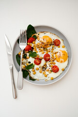 A nutritious and Healthy Breakfast featuring Eggs, fresh Tomatoes, and vibrant Spinach, chickpeas.