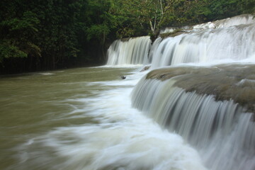 Fototapeta premium Pa La Tha Waterfall is a beautiful limestone waterfall. Its highlight is the waterfall's long width, clearly descending into 3 levels. It is most beautiful during the rainy season. Umphang ,THAILAND