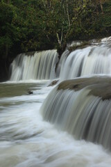 Fototapeta premium Pa La Tha Waterfall is a beautiful limestone waterfall. Its highlight is the waterfall's long width, clearly descending into 3 levels. It is most beautiful during the rainy season. Umphang ,THAILAND