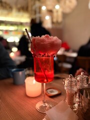 glass of cocktail on wooden table in restaurant. Pink cocktail