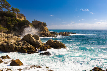 Olas rompiendo en rocas bajo un mirador en el camino costero entre Fenals y Lloret, Costa Brava.