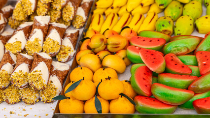 Sicilian cannoli filled with ricotta and marzipan fruits shaped as watermelon oranges and bananas...