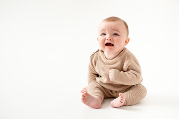 Fototapeta premium a crying baby on an isolated white background, a small boy crying or calling for his mother in a brown knitted suit