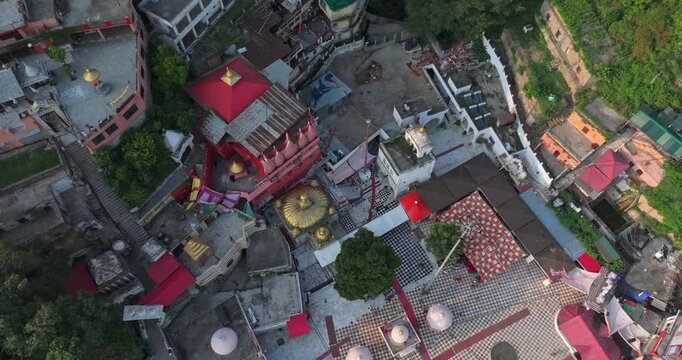 Aerial rising view revealing the full Jawalamukhi Jwala Ji Temple campus with golden dome in Kangra, Himachal Pradesh during evening golden hour, sacred Hindu Shakti Peeth pilgrimage site