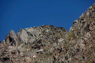 Hiking on the rugged peaks of Ahorn mountain in Mayrhofen, Austria on a clear sunny day