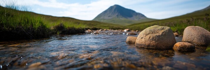 This scenic image captures a peaceful stream winding through lush landscapes, with a stunning mountain backdrop, evoking a sense of connection to nature&rsquo;s beauty.