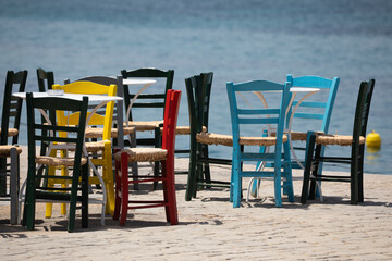 Painted wooden chairs in Greek taverna on waterfront, Koroni, Peloponnese, Greece