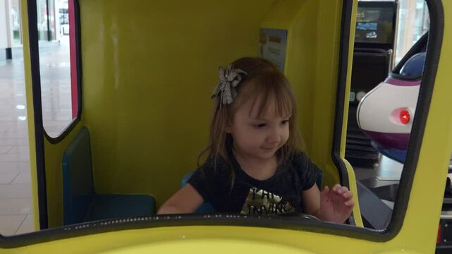 Little Girl Playing in Kiddie Ride Car