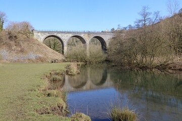 Fototapeta premium Monsal Viaduct reflected in the River Wye, Monsal Dale Derbyshire England 