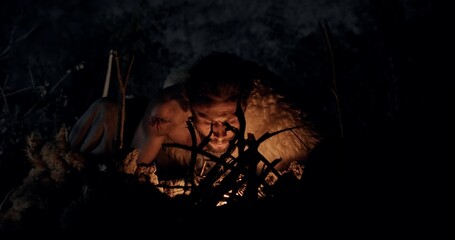 Cave Dweller Lighting a Fire at Night in a Primitive Setting Surrounded by Darkness and Nature