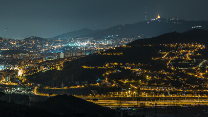 Barcelona and Badalona skyline with roofs of houses and sea on the horizon night timelapse