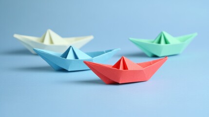 Colorful paper boats on blue background.