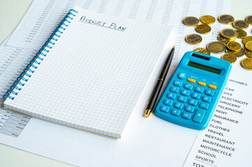 Notebook with family budget, calculator table, and money next to it. Price increases and economic difficulties.

