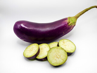 A fresh chopped eggplant rests against a white background, showcasing its deep purple hue and smooth