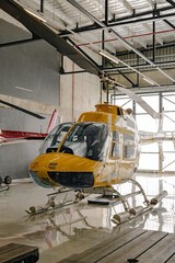 Yellow tourist helicopter in hangar, rotary-wing aircraft