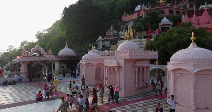 Aerial pullback revealing Jawalamukhi temple courtyard with devotees in warm evening golden light at Jwala Ji Temple in Kangra, Himachal Pradesh, sacred Hindu pilgrimage site