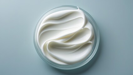 Creamy white whipped substance in a clear bowl on a smooth surface